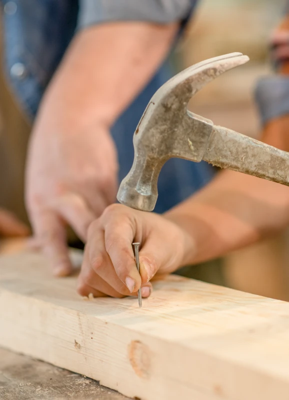 Un professionnel en train de clouer un bois